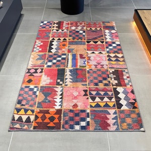 Puede incluir: Una alfombra de patchwork colorida con una variedad de patrones geométricos en tonos de rojo, azul, amarillo y naranja.