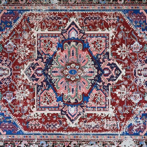 K&ouml;nnte beinhalten: Ein Vintage-Teppich mit einem verblassten geometrischen Muster in Rot, Blau und Rosa. Der Teppich hat einen abgenutzten und verwitterten Look mit Bereichen, die verblasst und abgenutzt sind.