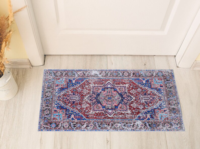 K&ouml;nnte beinhalten: Ein blauer und roter Teppich mit einem verblassten, Vintage-Look. Der Teppich hat ein traditionelles persisches Design mit komplizierten Details.
