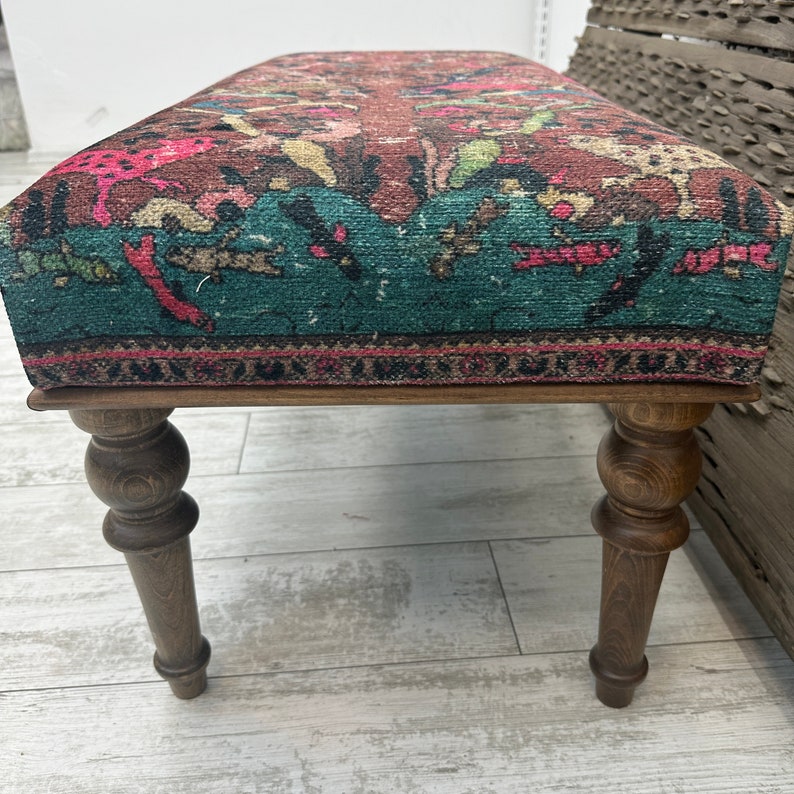 Peut inclure: Un banc en bois avec des pieds tourn&eacute;s et un si&egrave;ge en tissu &agrave; motifs color&eacute;s. Le tissu est de couleur turquoise, rose et marron.