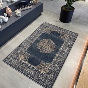 May include: A dark blue and beige patterned rug with a central medallion design. The rug has a distressed look and is made of a soft, woven material.