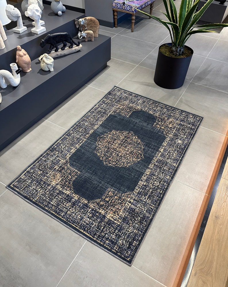 May include: A dark blue and beige patterned rug with a central medallion design. The rug has a distressed look and is made of a soft, woven material.