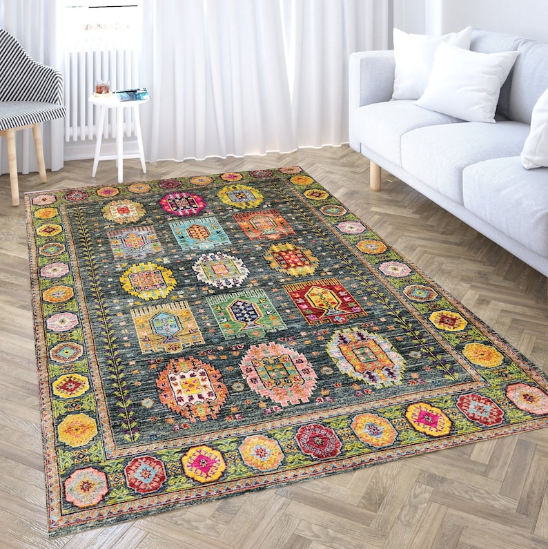 May include: A colorful rug with a geometric pattern in shades of blue, green, yellow, red, and pink. The rug has a dark blue background and a border with a floral design.