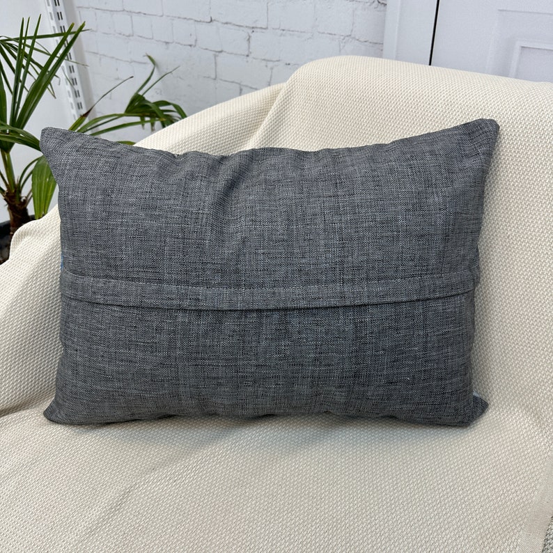 May include: A dark gray throw pillow with a zipper closure on the back.