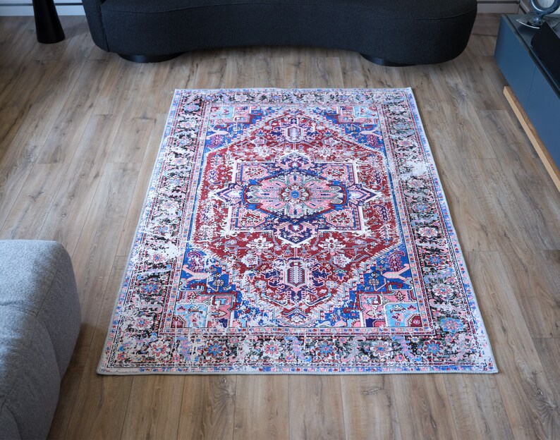 K&ouml;nnte beinhalten: Ein rot-blau-wei&szlig;er Teppich mit traditionellem persischem Design. Der Teppich hat einen wei&szlig;en Hintergrund mit einem zentralen Medaillon und komplizierten Blumenmustern.