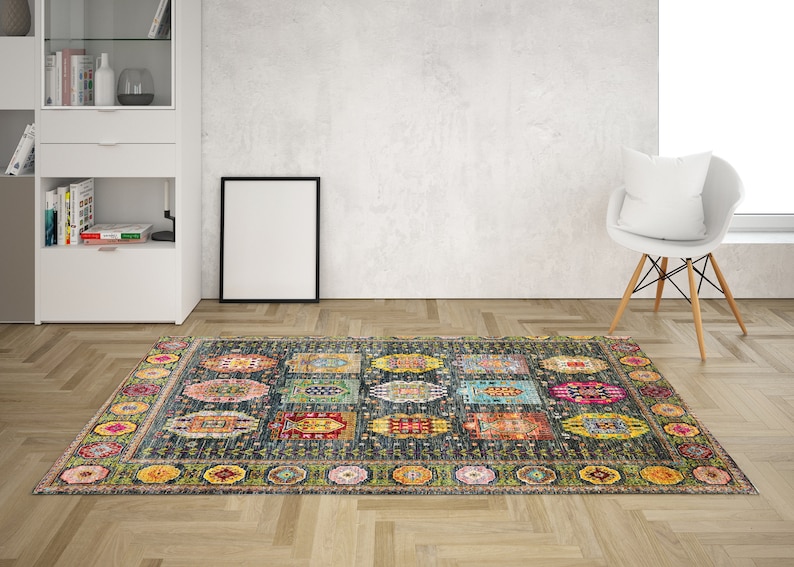May include: A colorful patterned rug with a dark blue background and a border of green, yellow, and pink. The rug has a geometric design with various shapes and colors.