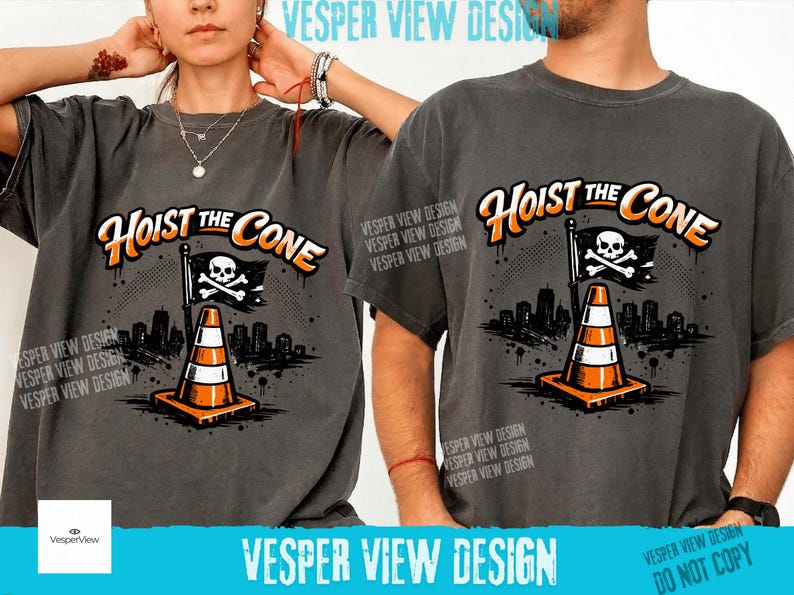Peut inclure: T-shirts gris fonc&eacute; avec l'inscription "Hoist the Cone" en orange et blanc. Le motif repr&eacute;sente un c&ocirc;ne de signalisation, un drapeau avec une t&ecirc;te de mort et des os crois&eacute;s, et un paysage urbain. La marque "Vesper View Design" est &eacute;galement visible.