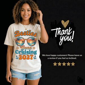 Peut inclure: T-shirt cr&egrave;me avec l'inscription "Besties Gone Cruising 2027" en orange, bleu et turquoise. Le motif comprend des lunettes de soleil avec une sc&egrave;ne de plage. Le t-shirt a aussi "Thank you!" sur fond noir.