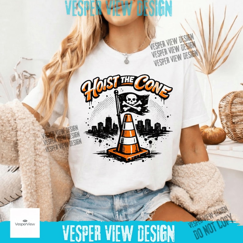 Peut inclure: T-shirt blanc avec un motif graphique repr&eacute;sentant un c&ocirc;ne de signalisation orange et blanc, un drapeau avec une t&ecirc;te de mort et des os crois&eacute;s, et le texte "Hoist the Cone". Le motif comprend une silhouette de ville et un fond pointill&eacute;.