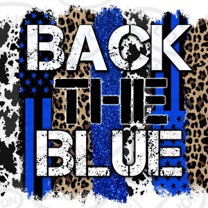 Può includere: Design grafico con la scritta "BACK THE BLUE" in bianco, su uno sfondo di vari motivi. Questi includono una stampa di mucca, una sezione glitterata blu, una stampa leopardata e un design a bandiera americana blu e nera.
