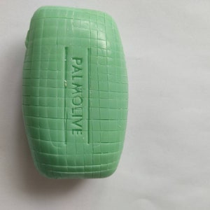 May include: A green bar of soap with the word "PALMOLIVE" embossed on the side.