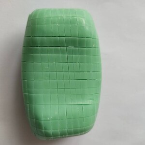 May include: A green bar of soap with a grid pattern on the surface.