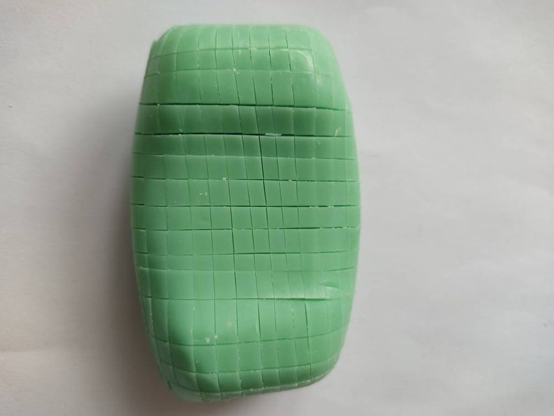 May include: A green bar of soap with a grid pattern on the surface.