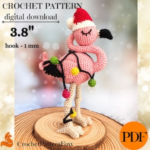 May include: Crochet pattern for a pink flamingo wearing a Santa hat and Christmas lights. The pattern is 3.8 inches tall and uses a 1 mm hook. The pattern is available as a digital download in PDF format.
