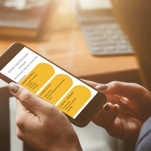 May include: A smartphone displays a wellness guide titled "Sitting Too Long Reset." The screen features three sections with exercise instructions. The phone is held by a person with manicured nails, suggesting a focus on health and well-being.