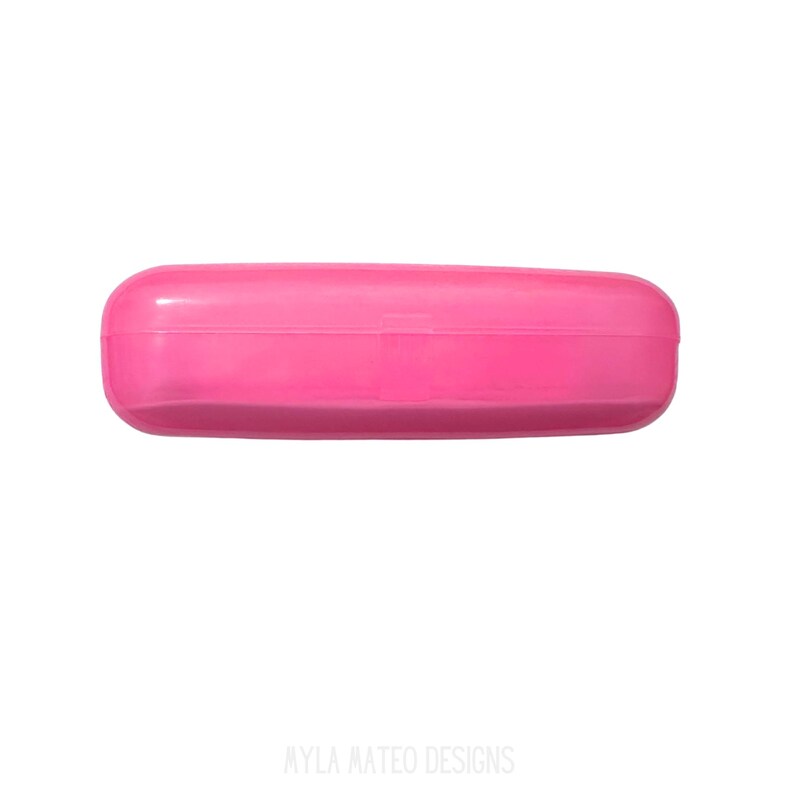 May include: A bright pink, rectangular hard-shell glasses case with rounded edges and a smooth, solid-colored finish. The case features a horizontal seam running across the middle, indicating a hinged opening mechanism for storing eyewear.