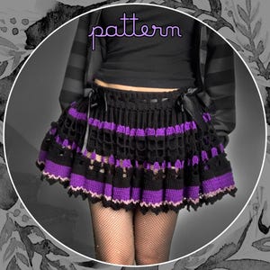 May include: Black and purple crochet skirt with a scalloped hem. The skirt features a layered design with openwork and solid bands of color. The word "pattern" is written in a cursive font across the top of the image.