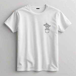 Könnte beinhalten: Weißes T-Shirt mit Rundhalsausschnitt und kurzen Ärmeln. Auf der linken Brust ist eine kleine Schwarz-Weiß-Illustration eines Kaktus in einem Topf aufgedruckt. Das Shirt besteht aus einem weichen, leichten Stoff.