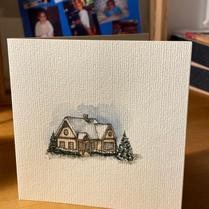 Carte carrée blanc cassé qui s'ouvre (12.1x12.1cm) avec enveloppe blanche. Chalet réalisé à l'aquarelle.