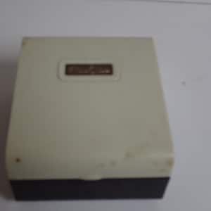 May include: A white plastic box with a black bottom. The box has a gold label with the word "Fashion" printed on it.