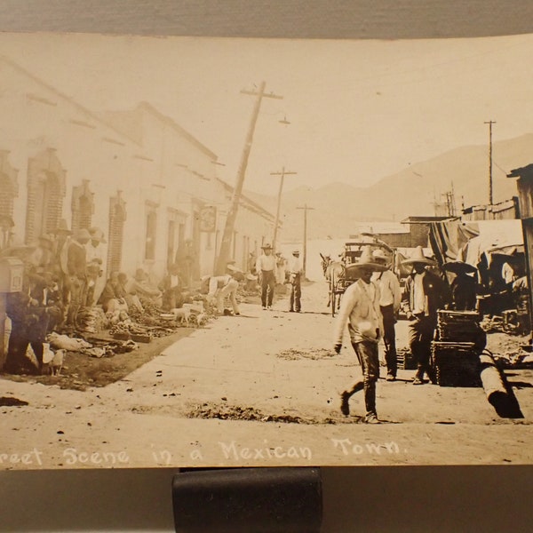real photo post card scene in Mexican town street market people and dogs