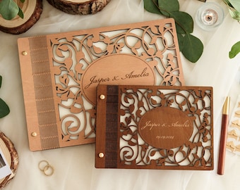 May include: Two wooden photo albums with intricate floral designs and cutouts. The albums are personalized with the names "Jasper & Amelia" and the date "09.09.2024".