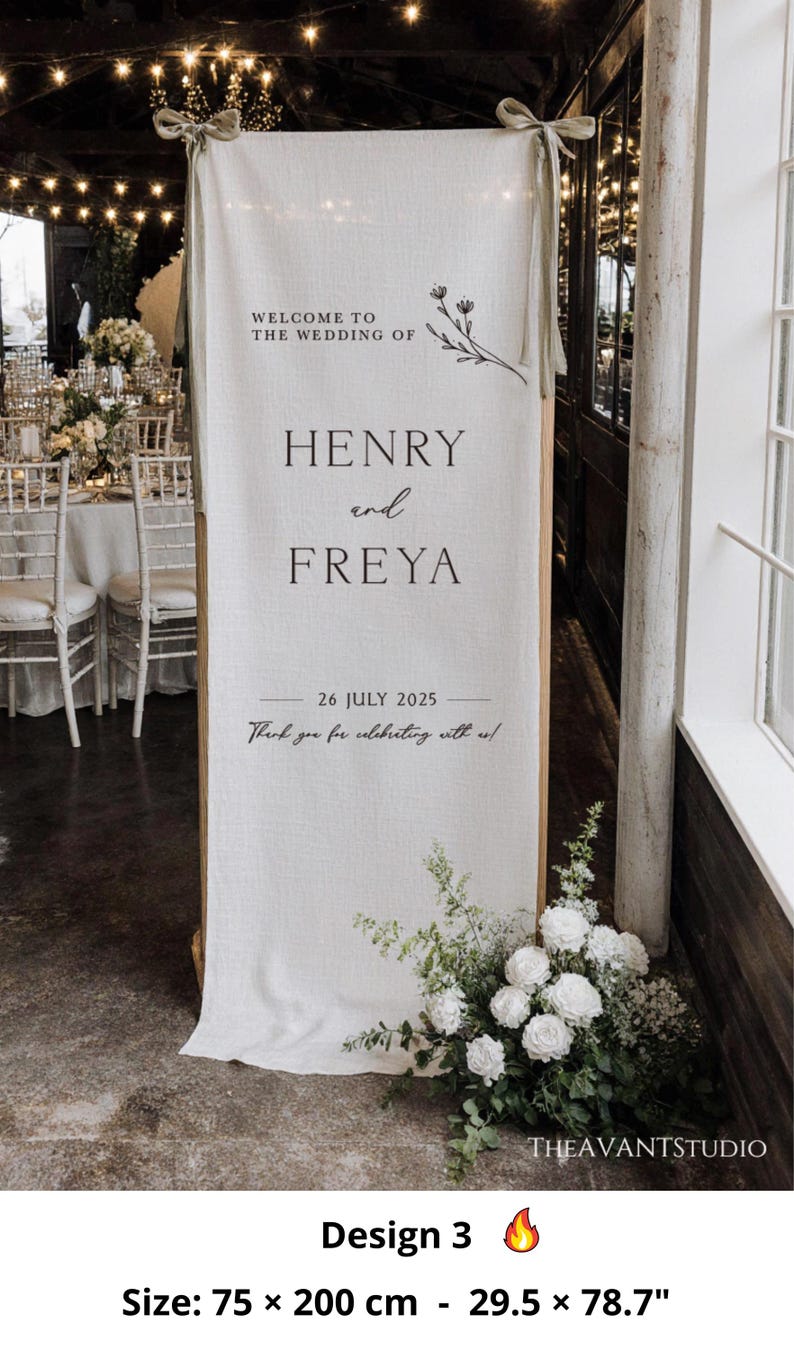 May include: A wedding welcome sign with the text "WELCOME TO THE WEDDING OF HENRY and FREYA" and the date "26 JULY 2025". The sign is made of a cream-colored fabric and is 29.5 inches wide and 78.7 inches tall. Floral arrangements are at the base.