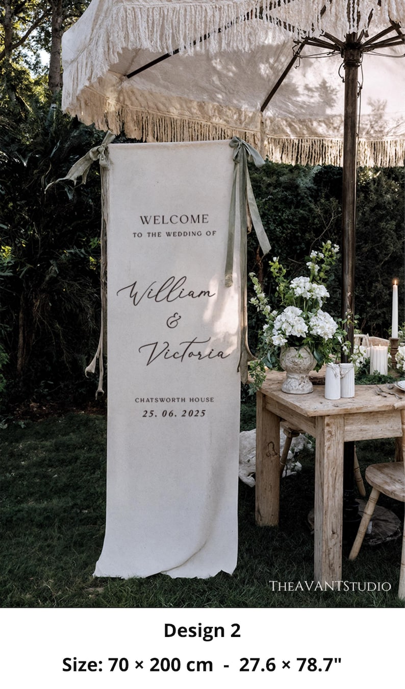 May include: A cream-colored wedding welcome sign with the text "WELCOME TO THE WEDDING OF William & Victoria" and the date 25.06.2025. The sign is 27.6 x 78.7 inches. The sign is hanging outdoors with a decorated table and flowers.