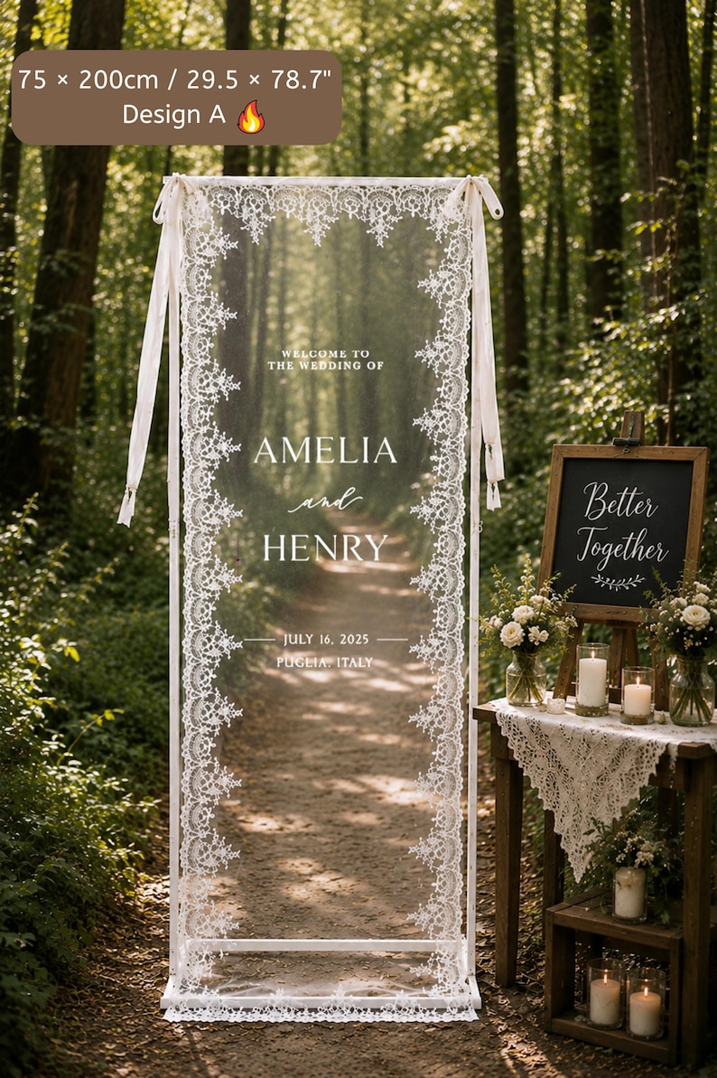Puede incluir: Un letrero de bienvenida para bodas rectangular de 75 por 200 cm, con un panel transparente enmarcado en blanco y adornado con encaje blanco. El texto dice: WELCOME TO THE WEDDING OF AMELIA and HENRY JULY 16, 2025 PUGLIA, ITALY. Dise&ntilde;o A.