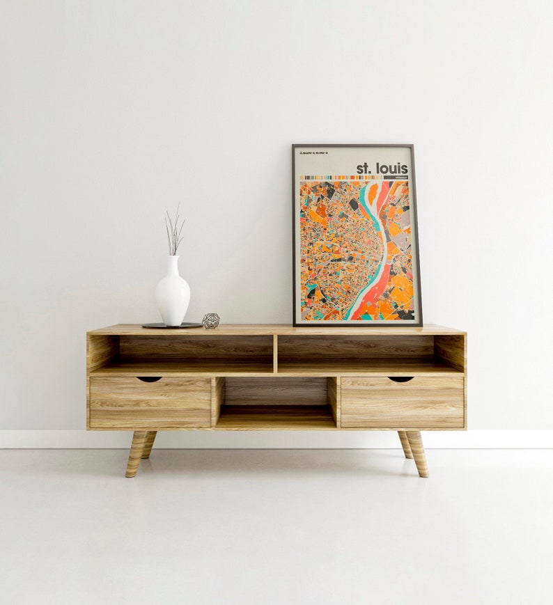 May include: A wooden entertainment center with two drawers and open shelves. A framed print of a colorful map of St. Louis, Missouri is on top of the entertainment center.