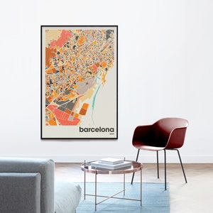 Może przedstawiać: Mapa Barcelony w Hiszpanii w czarnej ramie z kolorowym, abstrakcyjnym wzorem. Mapa wisi na białej ścianie. Wok&oacute;ł mapy znajduje się jasnoniebieski dywan, szara sofa, brązowy stolik kawowy i czerwone krzesło.