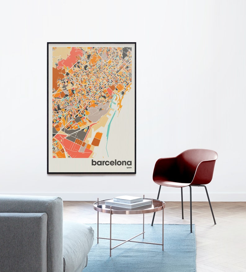 Może przedstawiać: Mapa Barcelony w Hiszpanii w czarnej ramie z kolorowym, abstrakcyjnym wzorem. Mapa wisi na białej ścianie. Wok&oacute;ł mapy znajduje się jasnoniebieski dywan, szara sofa, brązowy stolik kawowy i czerwone krzesło.