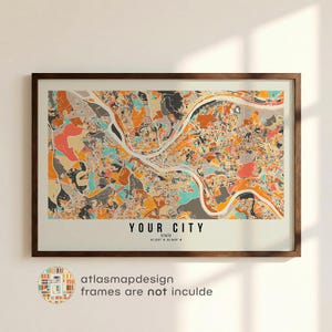 May include: A framed map print with a detailed, colorful city map design. The map features a mix of orange, teal, and gray tones, with a river running through it. The text "YOUR CITY" is displayed at the bottom, along with coordinates.