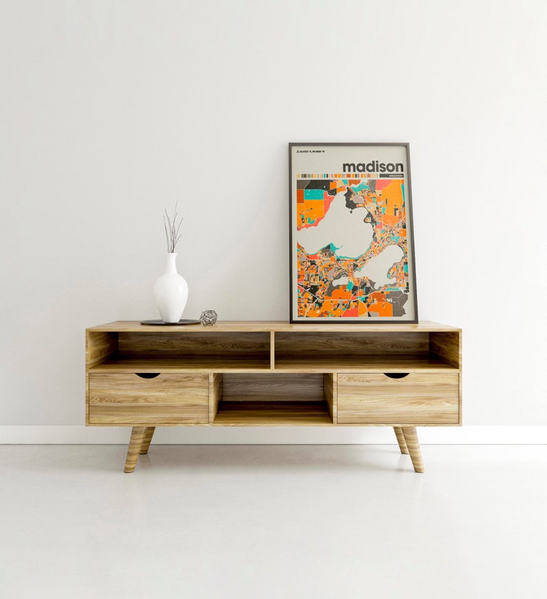 May include: A wooden entertainment center with two drawers and open shelves. A framed print of a map of Madison, Wisconsin, with the word "madison" in bold text, is displayed on the top shelf.