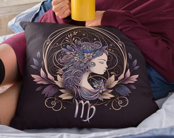 May include: A black throw pillow with a gold and purple illustration of a woman with flowers in her hair. The illustration is surrounded by a gold circle with the astrological symbol for Virgo in the center.