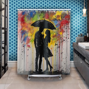 Puede incluir: Una cortina de ducha colorida con una silueta de una pareja de pie bajo una sombrilla. El fondo es un lienzo blanco con salpicaduras de pintura colorida.