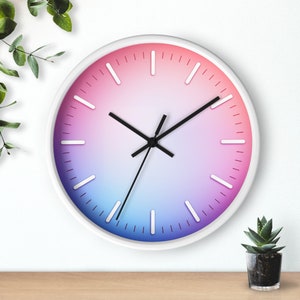 May include: A white analog clock with black hands and a gradient pink to blue face. The clock has white numbers and markings around the edge.