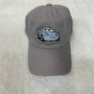 May include: A gray baseball cap with a blue cartoon car embroidered on the front.