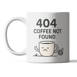 May include: White ceramic coffee mug with the text "404 COFFEE NOT FOUND" in dark grey. A cartoon coffee cup with a sad face is below the text. A small ball of yarn is next to the cup.