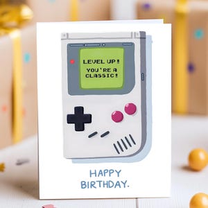 Cartão de Aniversário Retro para Gamer Portátil - "Suba de Nível! Você é um Clássico!" Cartão Vetorial Desenhado à Mão, Presente Nostálgico para Gamer