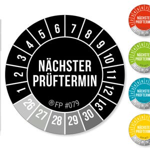 May include: A black permanent marker next to a set of inspection stickers. The main sticker is black and white, with the text "NÄCHSTER PRÜFTERMIN" and numbers around the edge. Additional stickers in red, green, blue, and yellow are also visible.