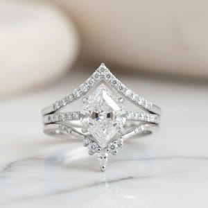 Peut inclure: Une tasse en c&eacute;ramique blanche avec une anse noire et l'inscription "But First, Coffee" en gras noir. La tasse contient un liquide fonc&eacute;, probablement du caf&eacute;, pos&eacute;e sur une surface claire.