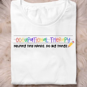 May include: White t-shirt with the text "OCCUPATIONAL THERAPY" in rainbow colors and "HELPING TINY HANDS. DO BIG THINGS." in black text with a yellow pencil icon.