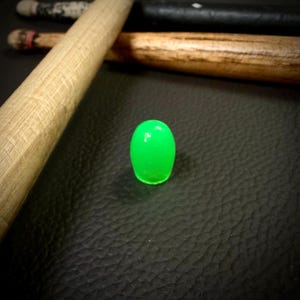 May include: A bright green glow-in-the-dark drumstick tip.