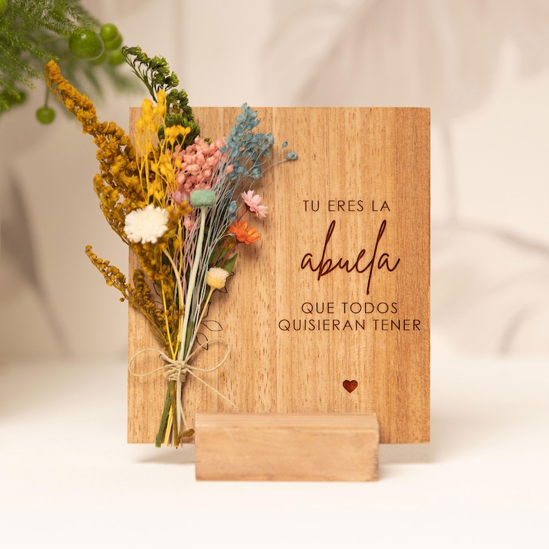 May include: Wooden sign with dried flowers and the text "Tu eres la abuela que todos quisieran tener" (You are the grandmother everyone would want to have).