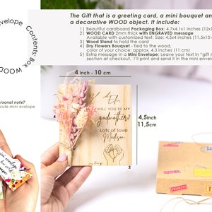 May include: A wooden card with a bouquet of dried flowers attached to it. The card says "Will you be my godmother?" with the name Madison and the text "Lots of love". The card is 4.5 inches by 11.5 inches.