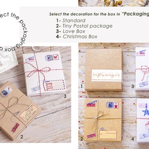 May include: Four different gift box packaging options. The first box is brown with the text "The flowering box" printed on it. The second box is brown with a twine bow and various stamps. The third box is white with a red twine bow and various stamps. The fourth box is white with a red and blue twine bow and various stamps, including a Santa Claus stamp.