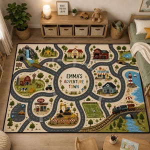 May include: A rectangular area rug featuring a colorful illustrated town map with roads, a central circle labeled EMMA'S ADVENTURE TOWN, a school, fire station, farm, gas station, vet clinic, lighthouse, soccer field, and train tracks.