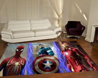 Puede incluir: Una alfombra rectangular con un estampado gráfico de tres superhéroes: Spider-Man con traje rojo y azul, el Capitán América sosteniendo un escudo circular rojo, blanco y azul, e Iron Man con traje rojo y dorado, con detalles de rayos azules.