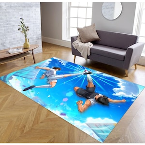 May include: A blue and white rug with an anime illustration of two soccer players in mid-air, one kicking a ball towards the other. The background is a blue sky with white clouds.